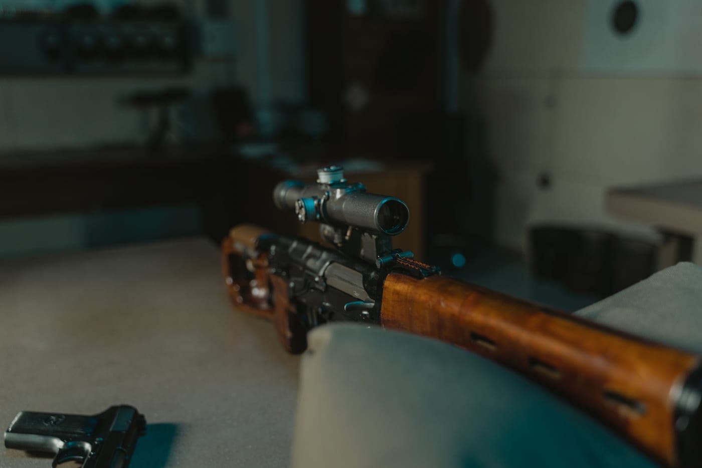 A bolt-action hunting rifle and optics on a bench at a rural shooting range